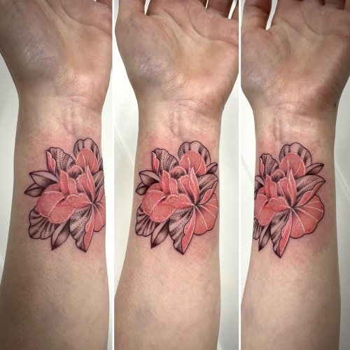 Hand poked saffron tattoo located on the wrist.